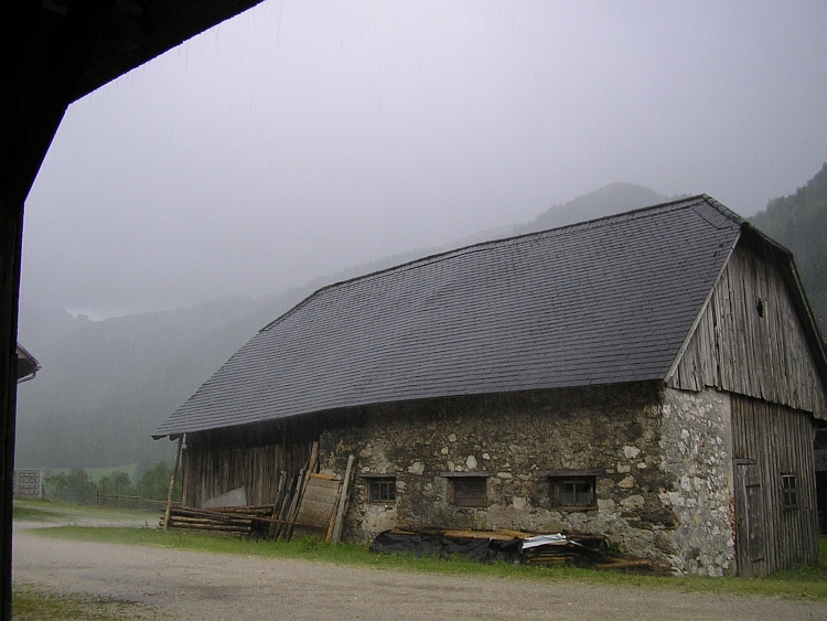 Schuilen voor de regen onder het afdak van een boerderij