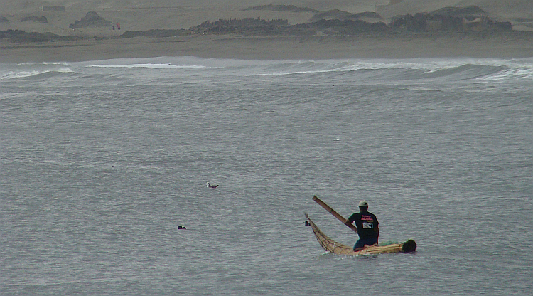 Fisherman in his little reed boat on the Pacific in Huanchaco